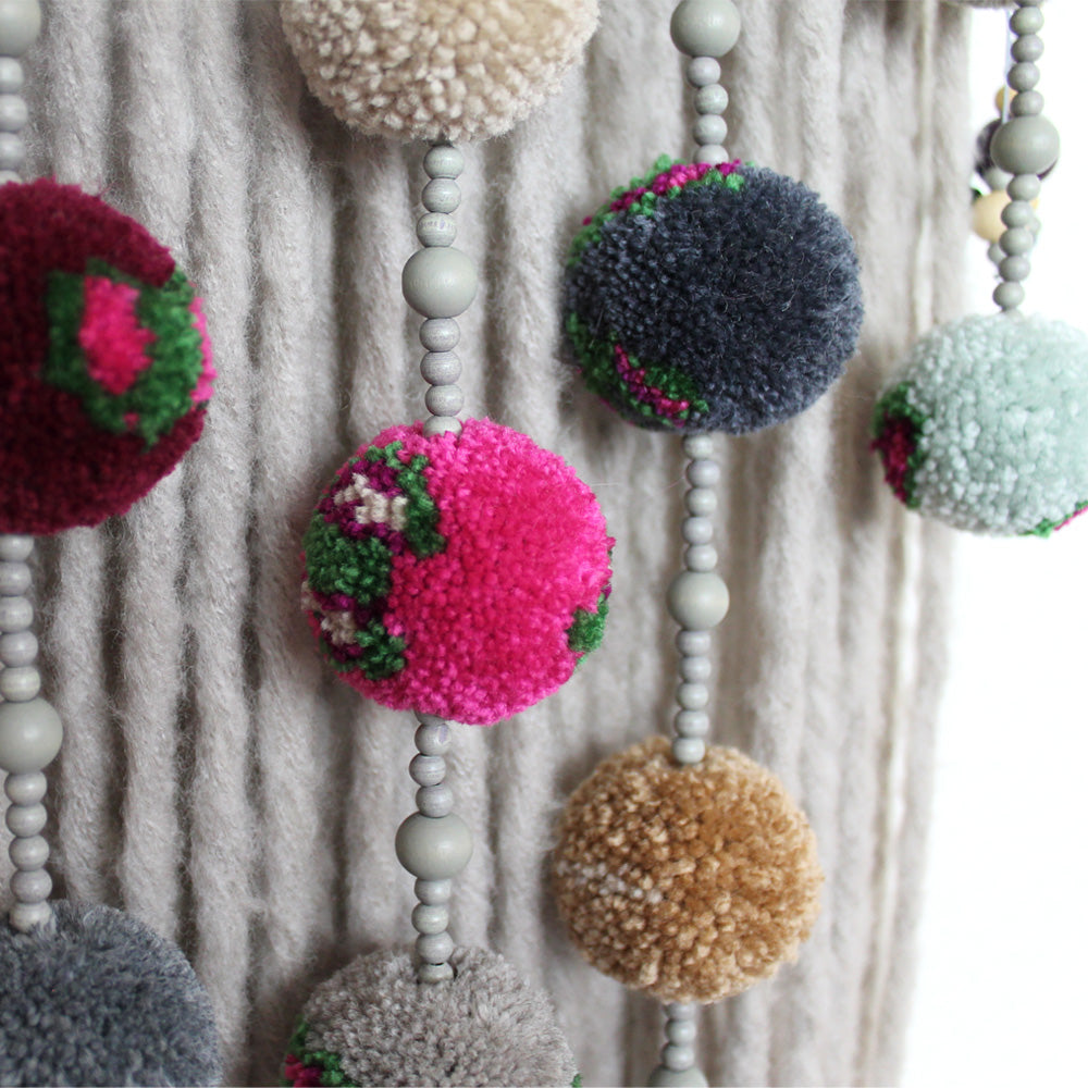Colgante de pared con pompones: detalles coloridos con cuentas de madera